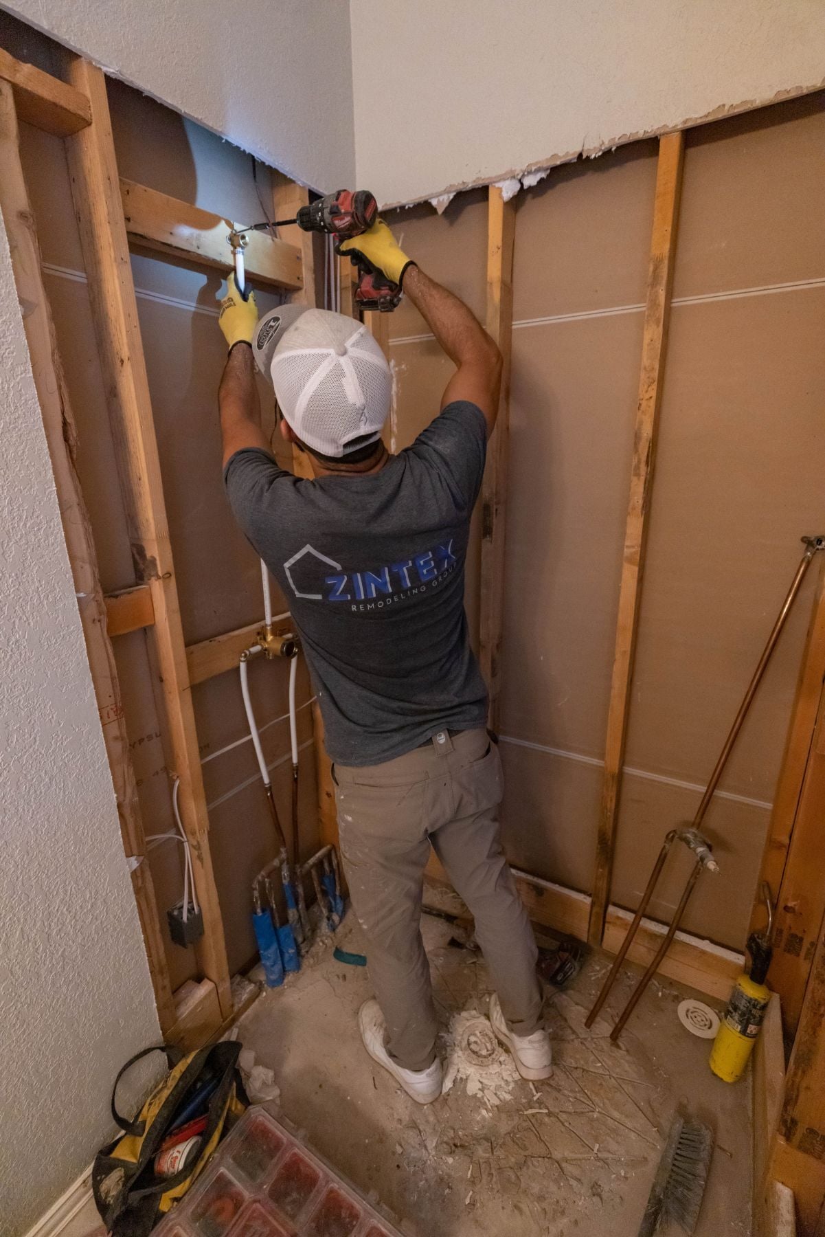 Photo of a ZINTEX installer addressing wet area structural issues before installing a new acrylic walk in shower