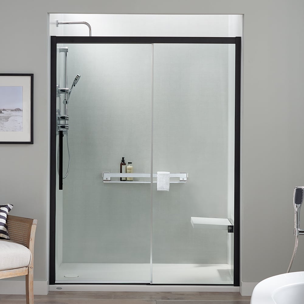 Photo of a walk in shower with a sliding glass door with matte black frame and a handheld showerhead