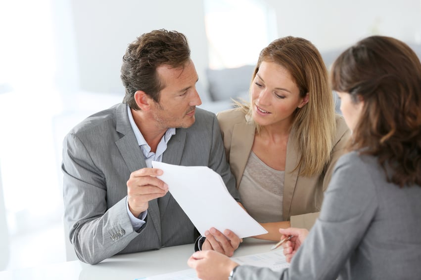 Photo of a couple talking to their financial adviser about qualifying for a bathroom remodel loan
