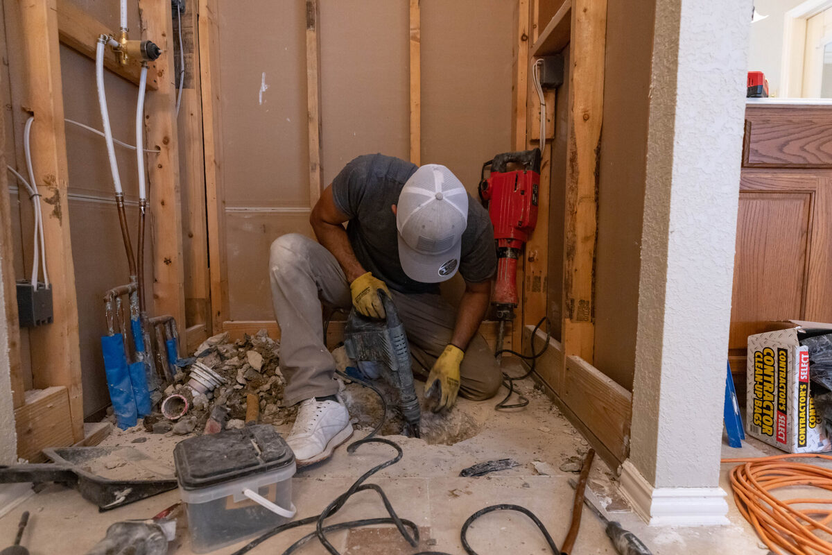 Photo of a ZINTEX installer working on the base of a walk in shower