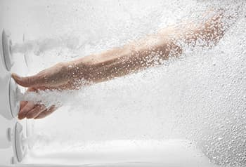 Concept photo of a hand reaching through water to adjust a bathtub jet