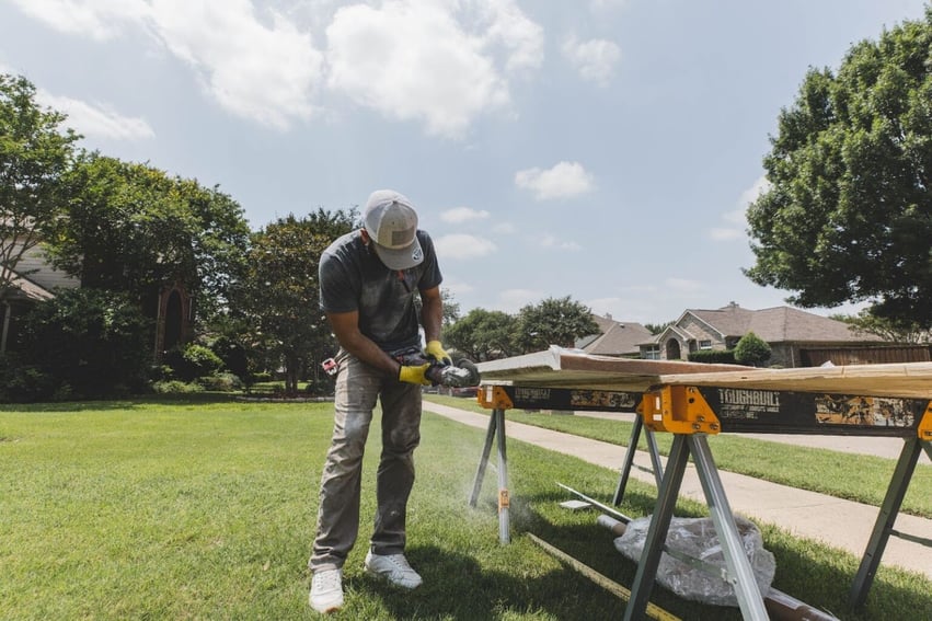 Photo of a ZINTEX installer cutting custom acrylic shower wall panels to the proper size
