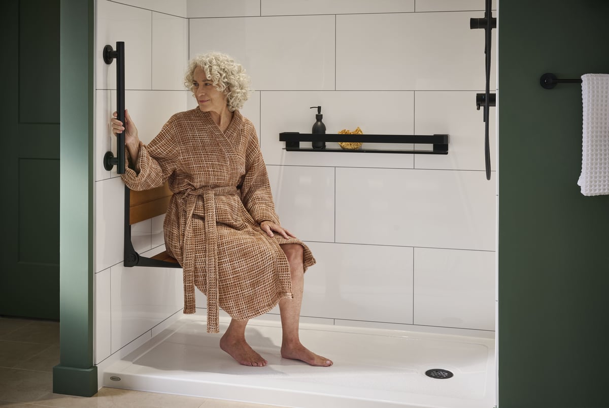 Photo of a woman sitting on the bench seat in her low threshold senior safety walk in shower