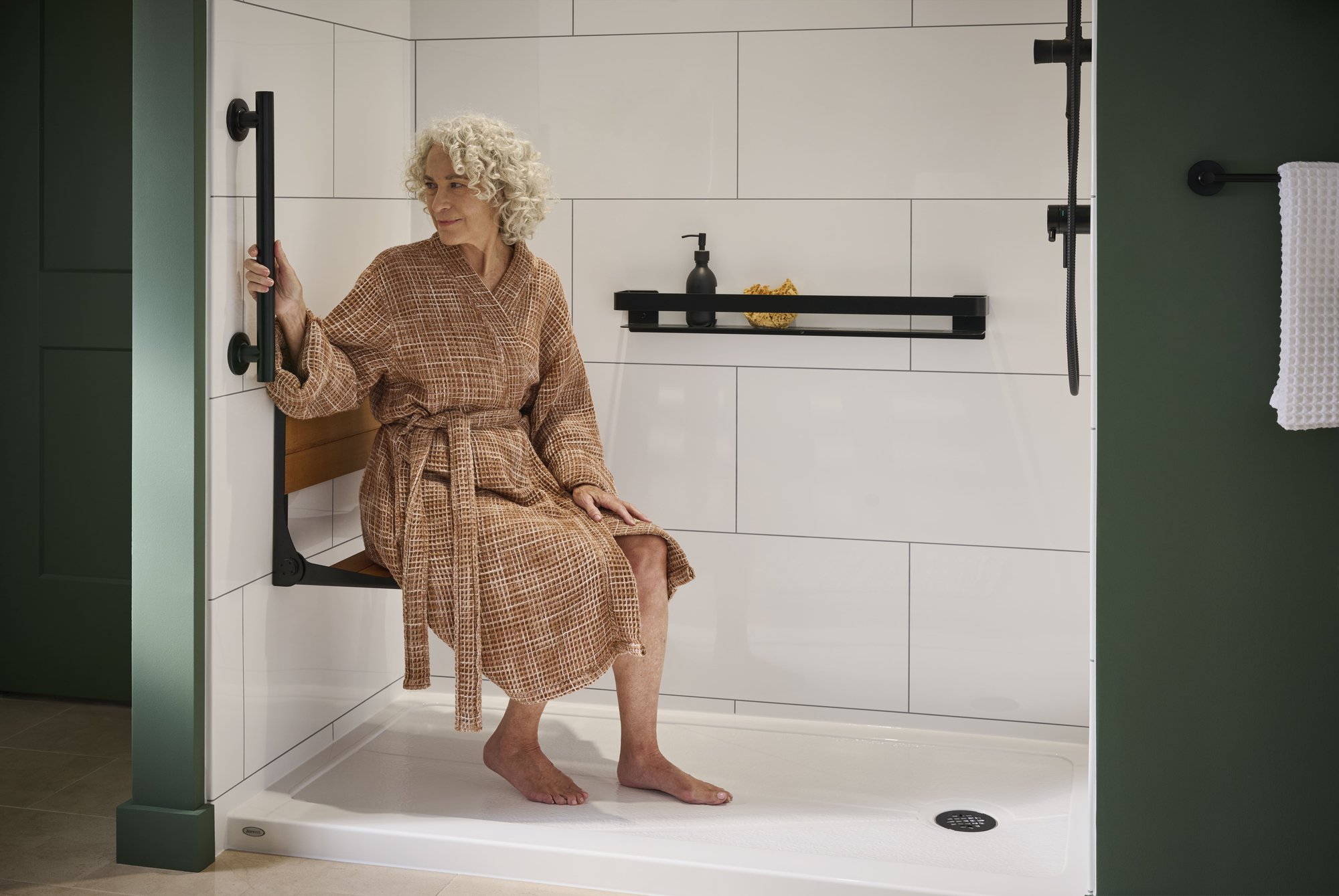 Photo of a woman sitting on the bench seat in her low threshold senior safety walk in shower