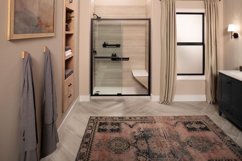 Photo of a bathroom with a Jacuzzi walk in shower with bench seating, grab shelves, and a glass sliding door