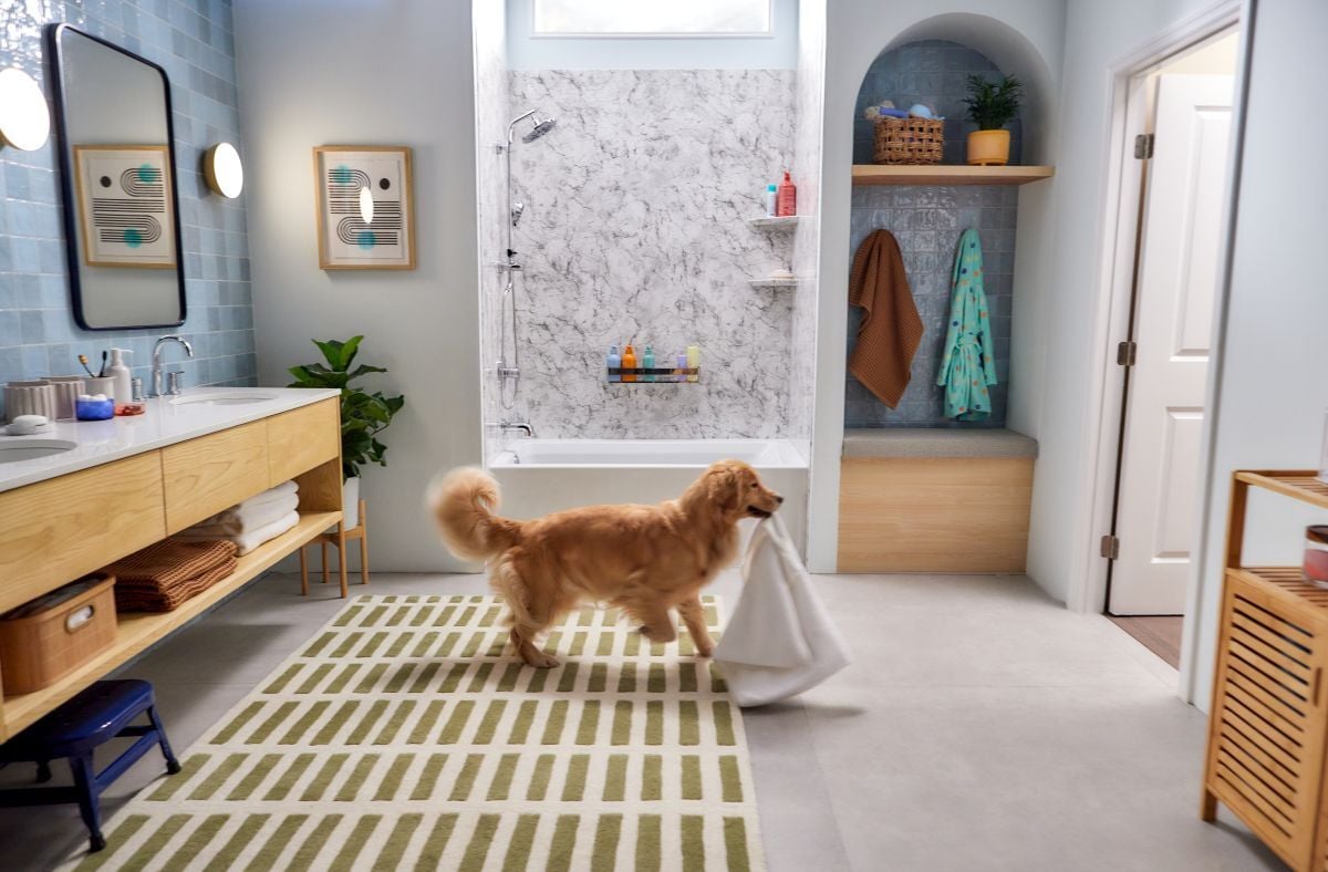 Photo of a spacious bathroom with a Jacuzzi bathtub and shower combination. A dog is in the forefront, playing with a towel.