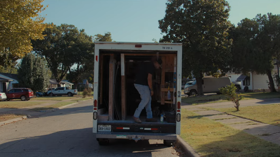 ZINTEX installer getting out of a work truck with new shower supplies
