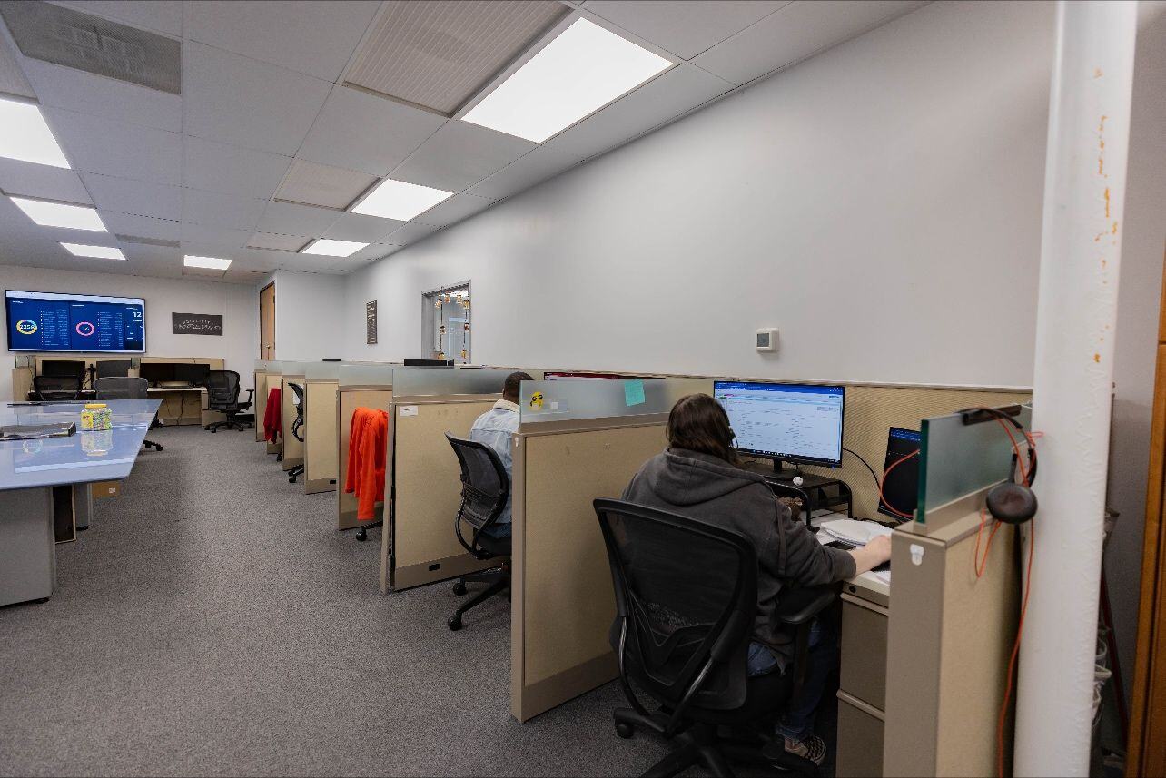 Photo of the ZINTEX call center showing several cubicles with employees sitting at their computers