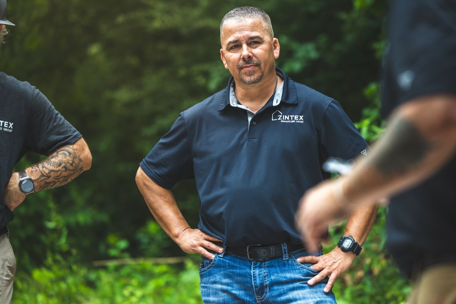 Photo of a ZINTEX team member standing outside listening to another team member