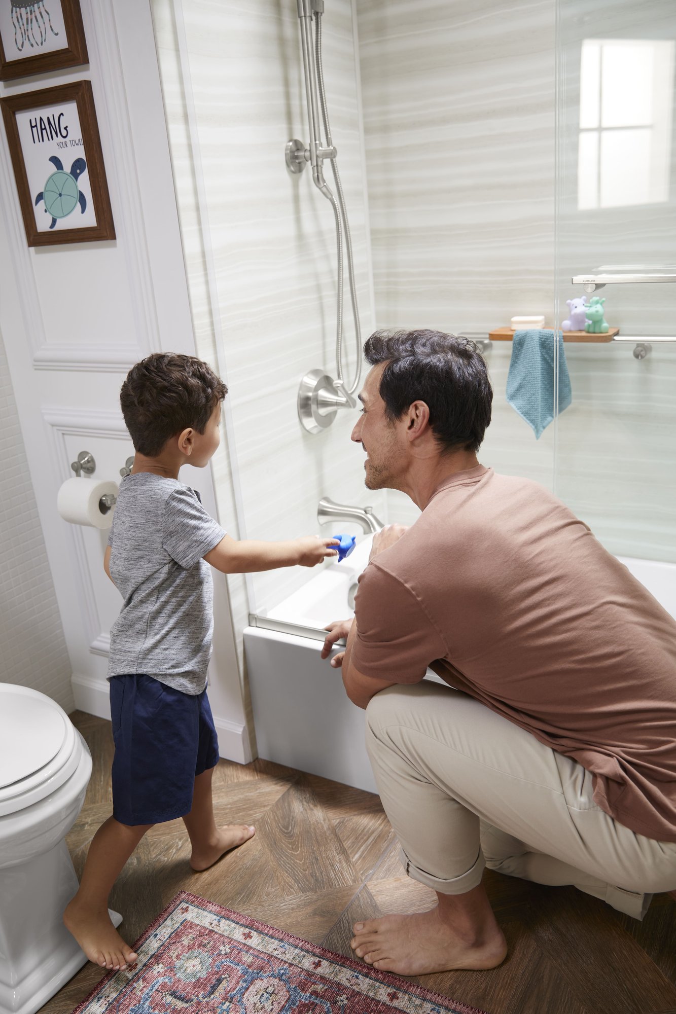 Photo of a father and son filling a tub and shower combo with built in storage