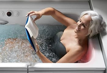 Photo of a woman reading a book in a premium walk in tub